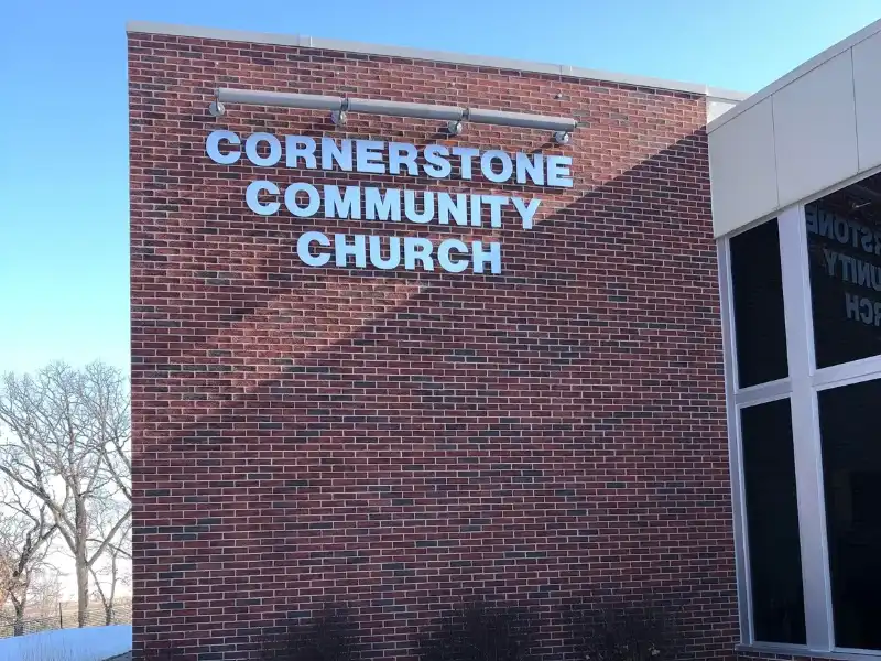 A brick building with the words cornerstone community church written on it.