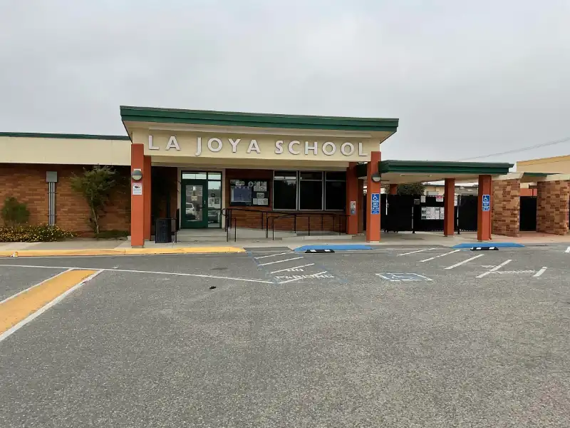 A school with a lot of parking spaces in front