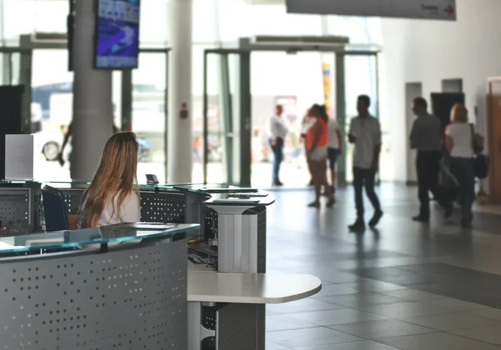 A woman sitting at the front desk of an airport.